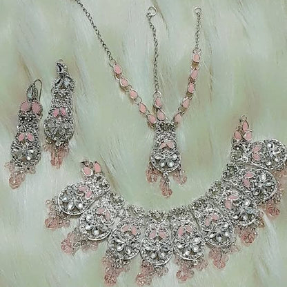 Jewelry set with necklace, earrings, and ring on a textured white background